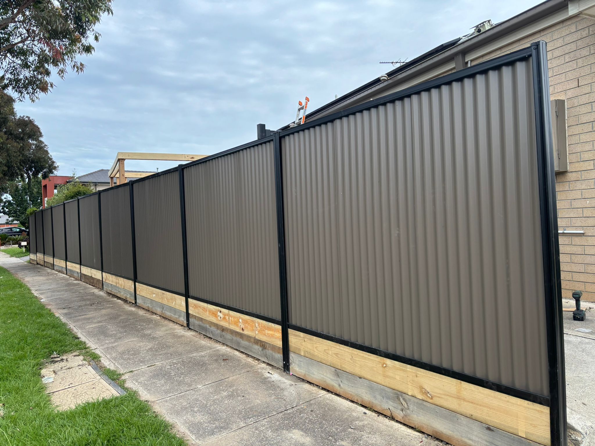 Concrete sleeper retaining wall installation with steel H-posts in progress
